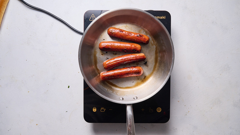 cooking hot dogs in skillet
