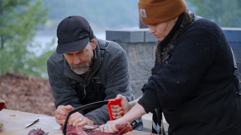 Nico cutting meat with saw