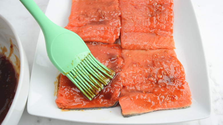 rubber brush brushing salmon with sauce