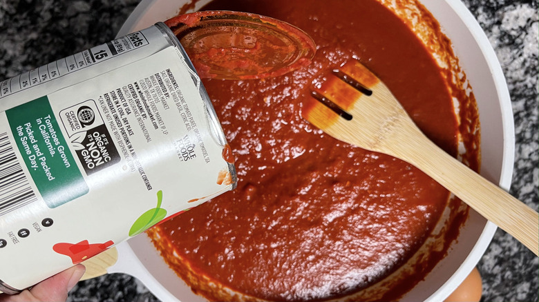 pouring tomatoes in pan