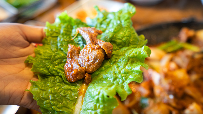 Wrapping grilled meat in lettuce