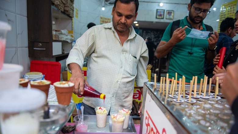 Vendor pouring sauce of kulfi