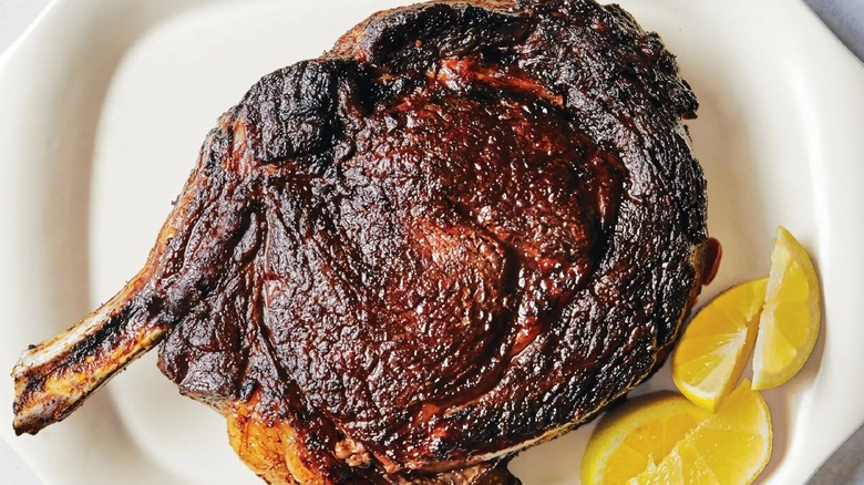 lacquered ribeye on a white plate with lemon