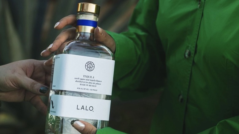 Bottle of Lalo being handed off