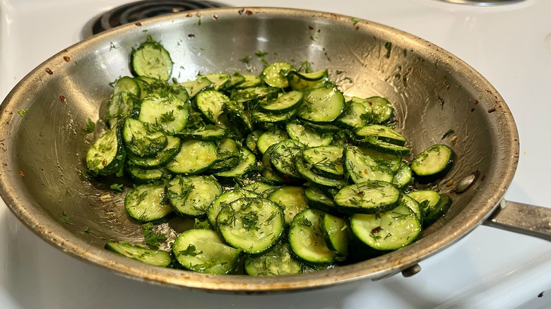 cooked sliced zucchini with herbs in a skillet