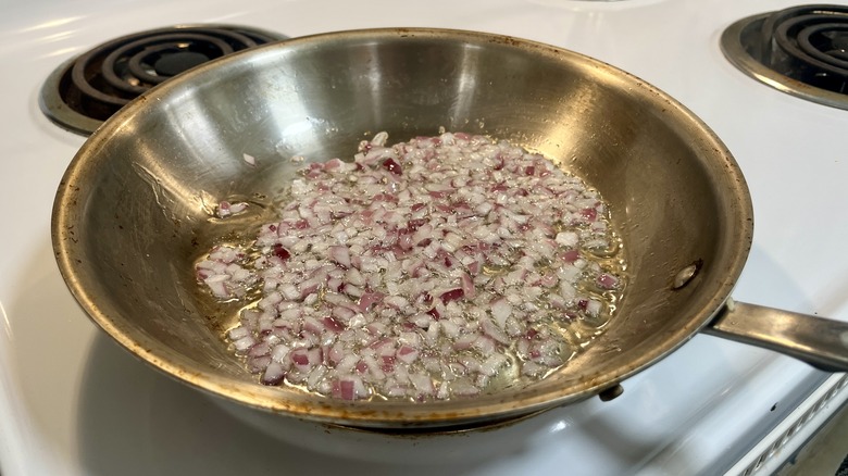 red onions sauteeing in a skillet