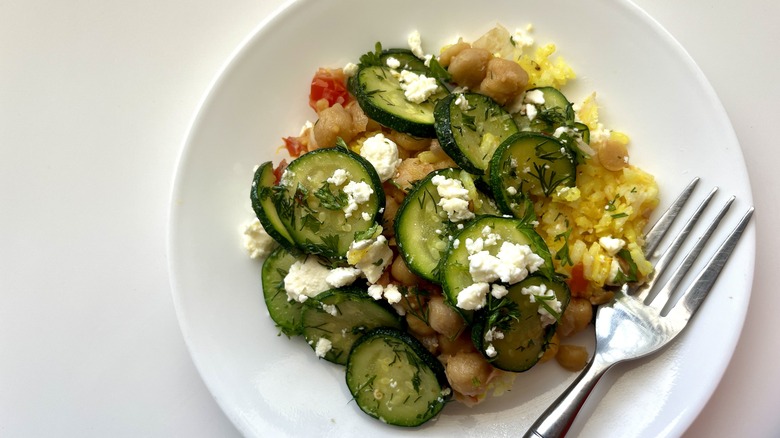 serving of layered zucchini casserole on a plate with a fork