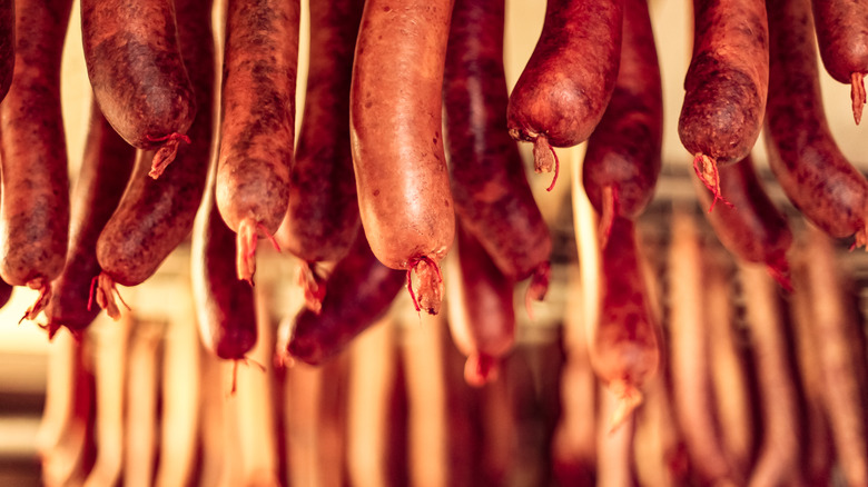 Fresh sausages hang in smokehouse 