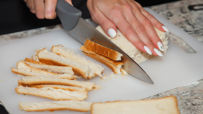 Hand cuts bread crusts 