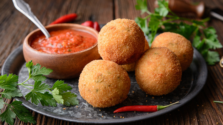 Arancini on plate with tomato sauce