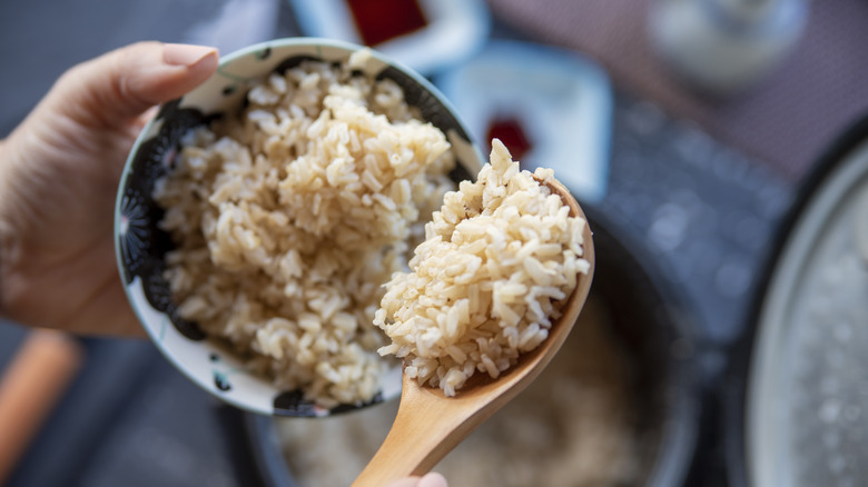 Hand holding bowl of rice