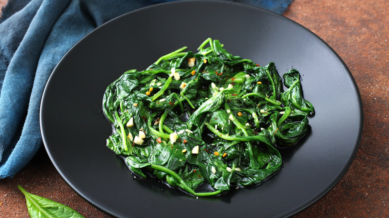 Cooked spinach in a black bowl