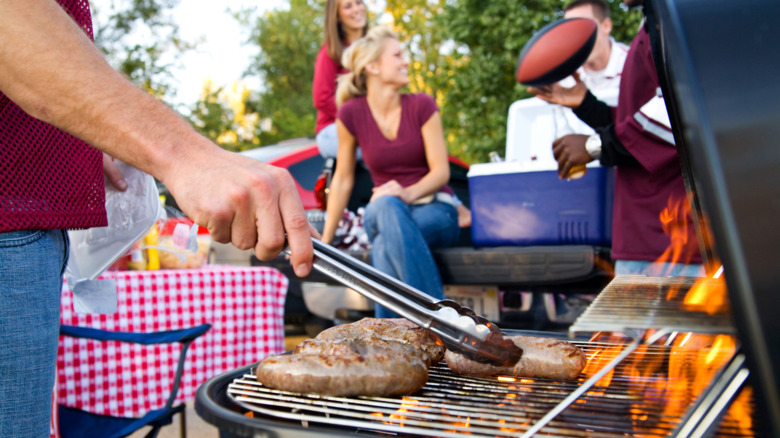 a crowd at a tailgate grilling party