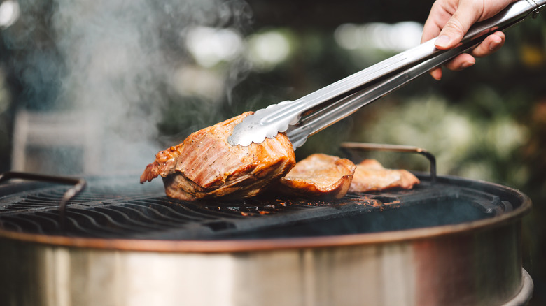 grilling meat over charcoal