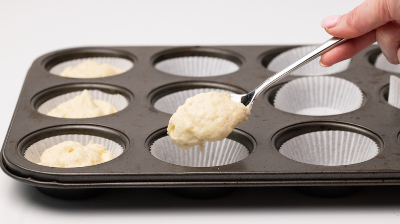 Scooping batter into cupcake cases 