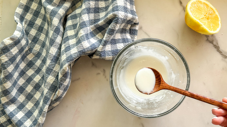 wooden spoon with lemon icing in bowl