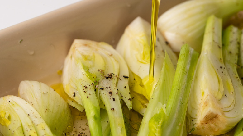 Pouring olive oil on fennel 