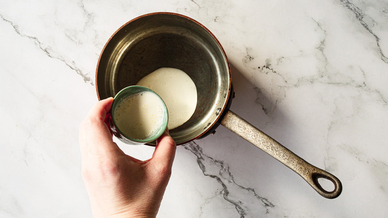 adding cream to saucepan