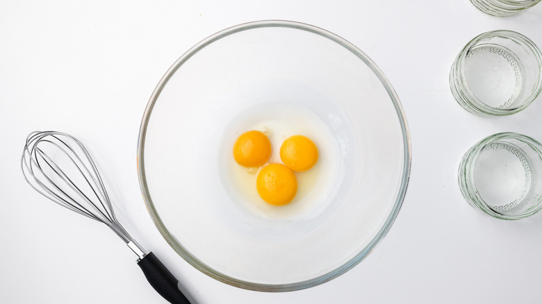 egg yolks in bowl with whisk