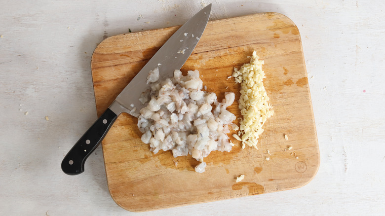 chopped garlic and shrimp on cutting board