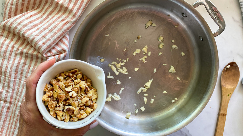 adding chopped walnuts to pan