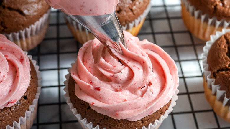 frosting cupcakes with pink buttercream