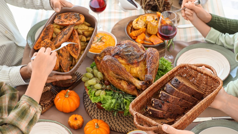 Hands passing Thanksgiving dishes at a table