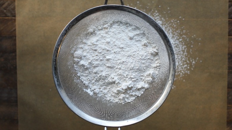 flour in sifter over parchment