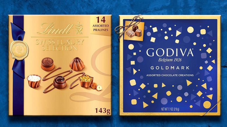 Lindt and Godiva chocolate boxes side by side on blue background