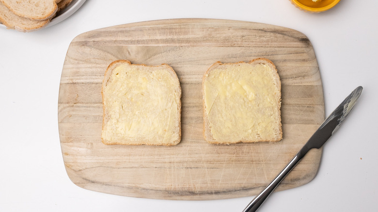 buttering bread on a board