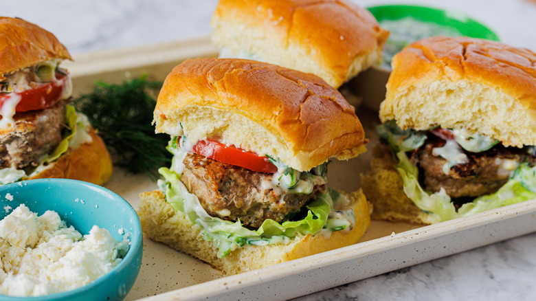 Four burgers with feta, dill and tomatoes