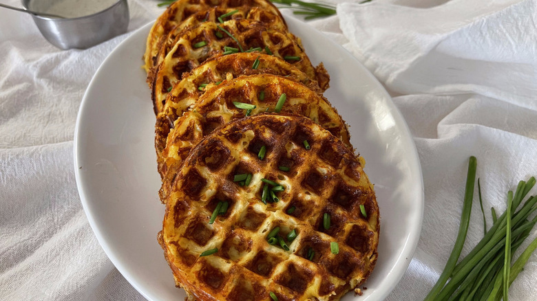 cheese waffles on white plate with chives