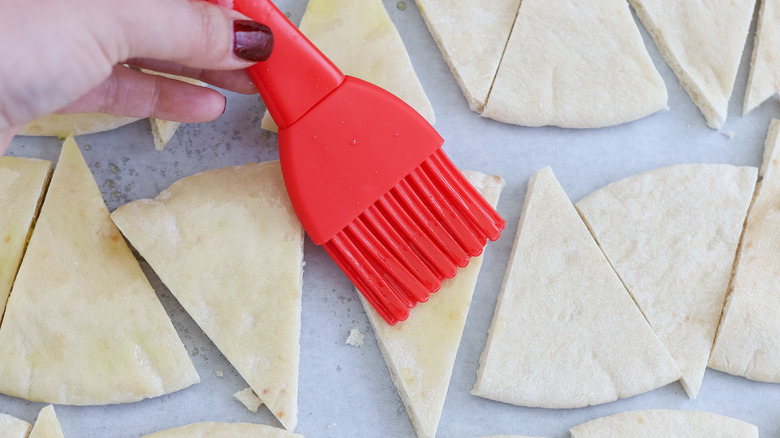 Pita being brushed with olive oil