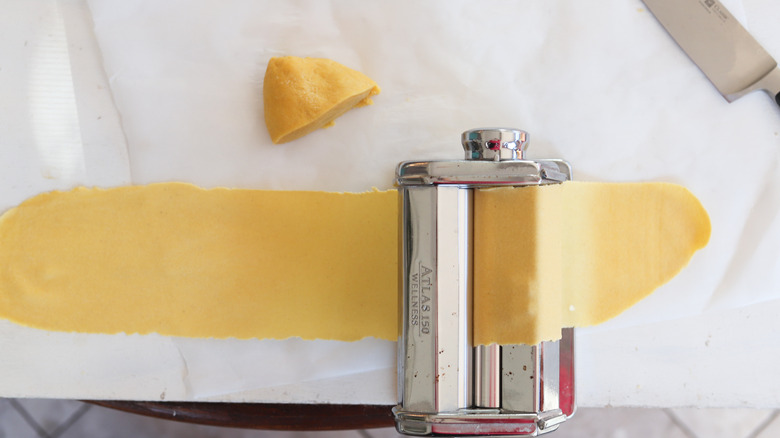 pasta dough rolled into a thin sheet in pasta roller