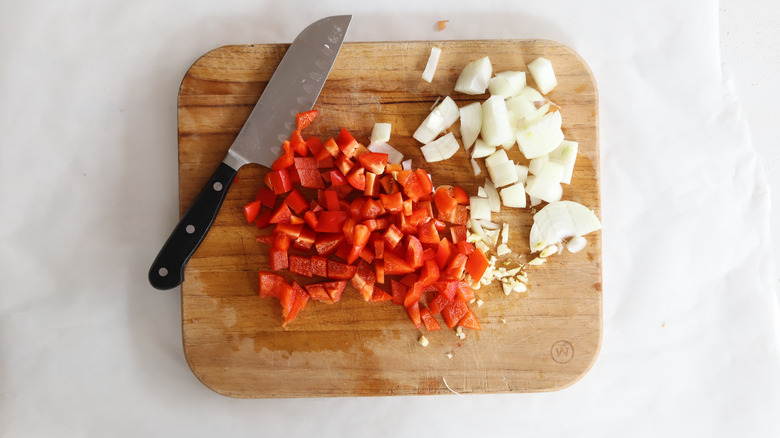 chopped vegetables on a cutting board with knife