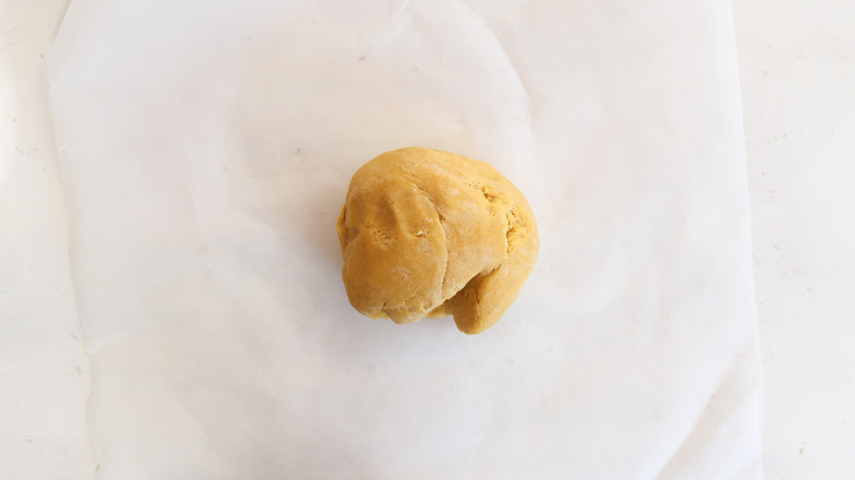 ball of pasta dough on parchment paper