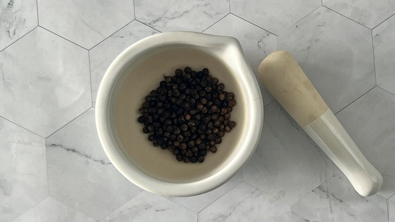 black peppercorns in white mortar