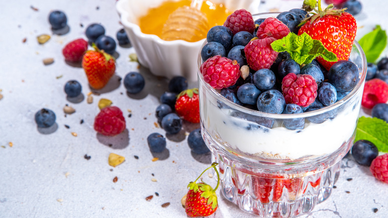 Summer diet healthy breakfast layered parfait dessert in a glass of mascarpone, blueberries, strawberry berries