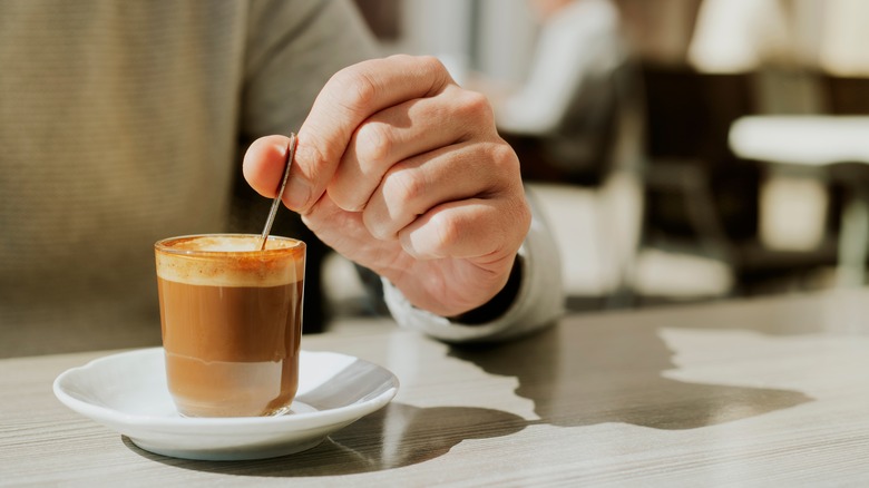 Person drinking a macchiato