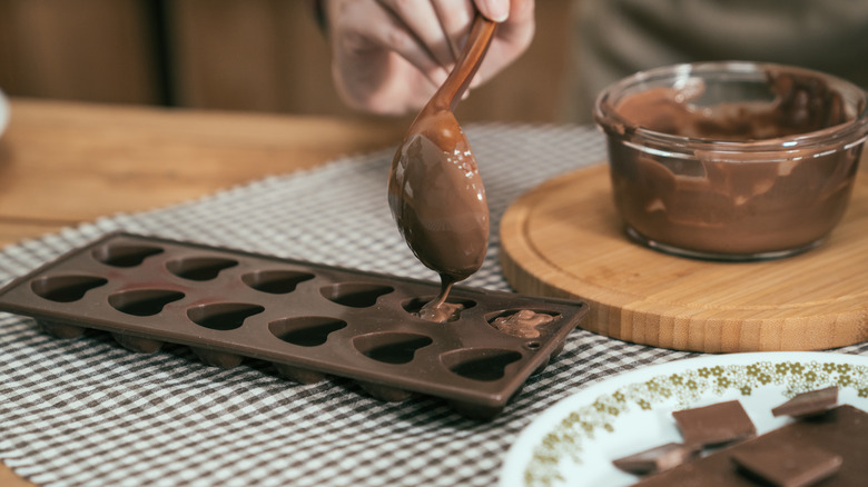 Pouring melted chocolate into silicone molds