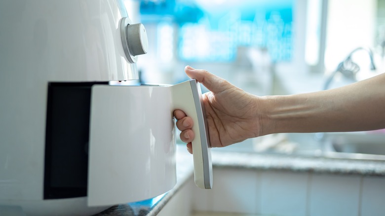 woman using air fryer