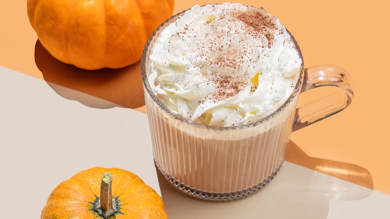 Spiced whipped cream coffee next to pumpkin