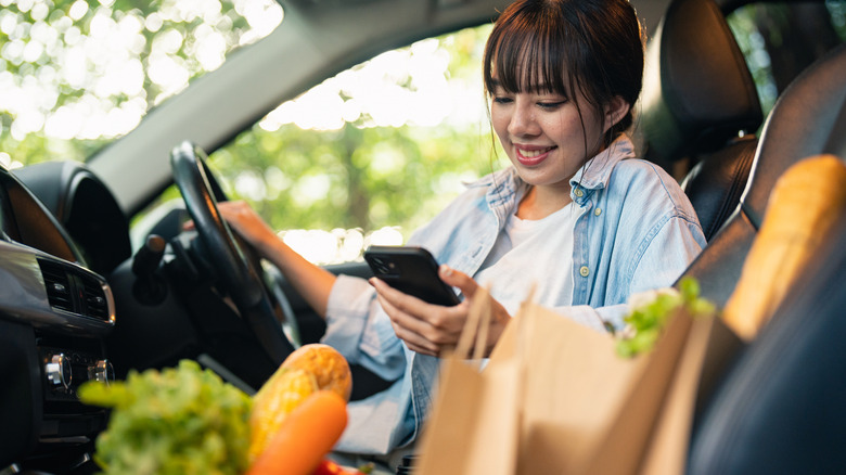A person in their car doing a grocery pick up