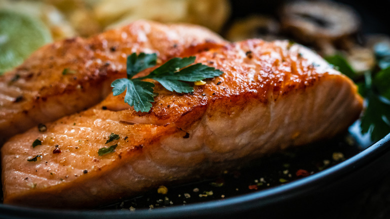 Cooked salmon filets garnished with parsley.