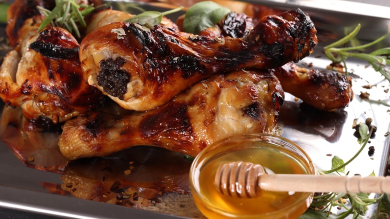 Cooked chicken pieces with a dish of honey glaze