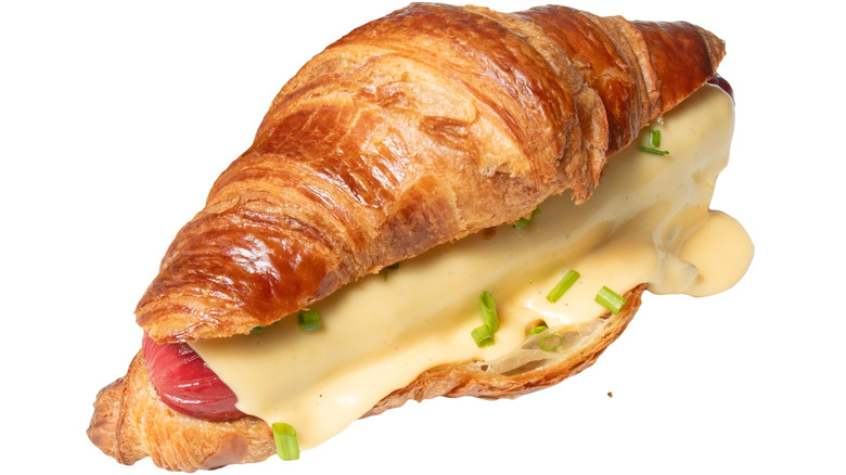 hot dog in croissant with cheese and chives