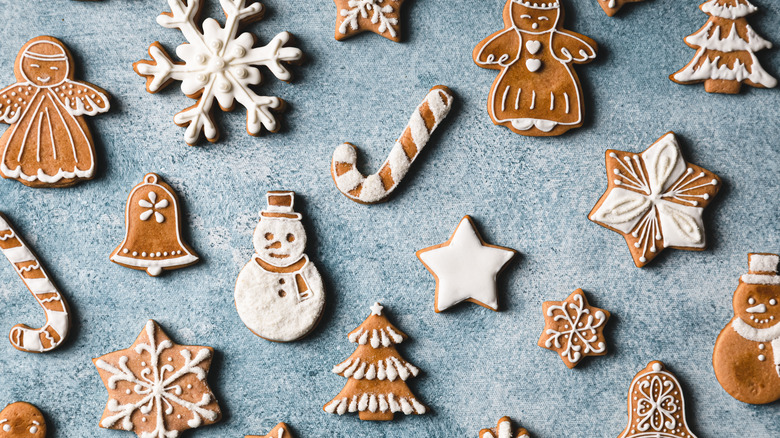 Decorated gingerbread cookies on blue surface