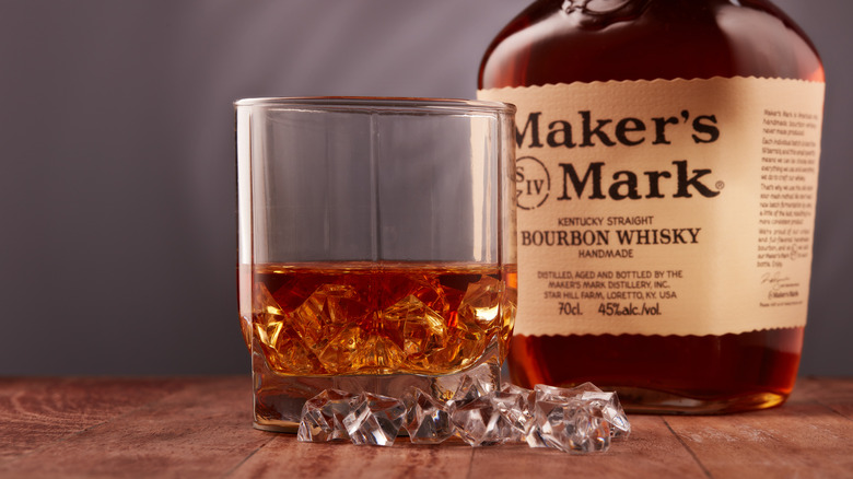 Glass of whiskey with Maker's Mark bottle