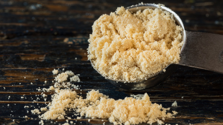 closeup of a teaspoon of malted milk powder on a wood surface