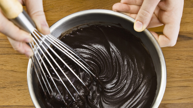 chef whisking chocolate frosting